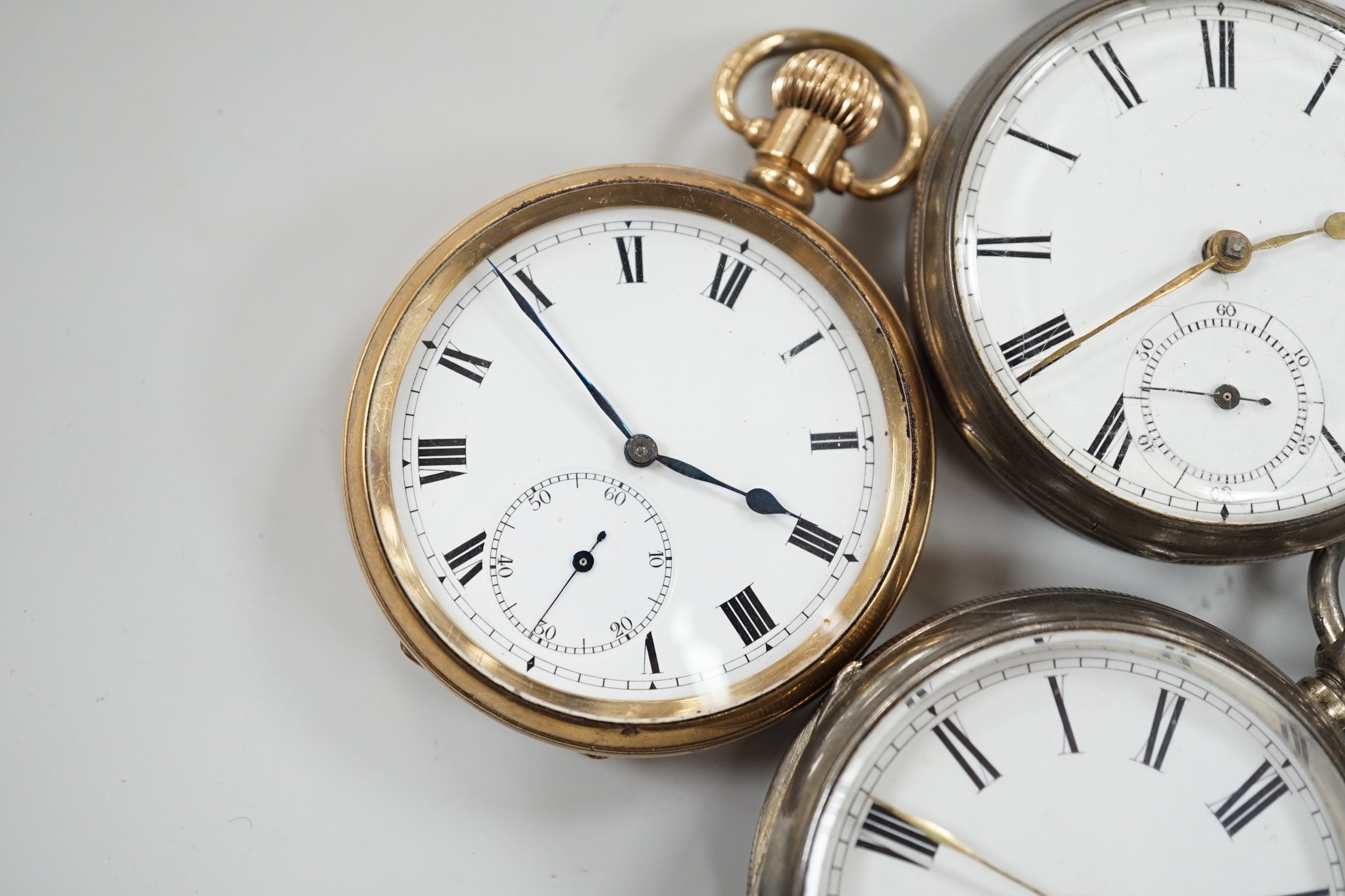 Three white metal open face pocket watches including two silver, one Waltham and a gold plated pocket watch.